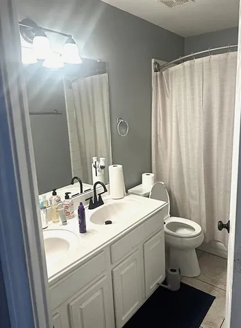a bathroom with a sink toilet and a mirror
