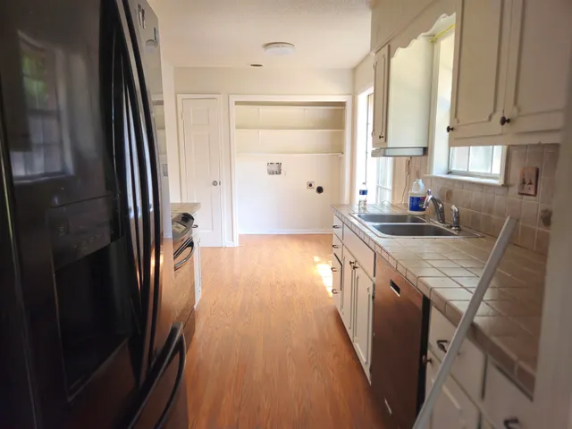 a kitchen with granite countertop a sink stove and refrigerator