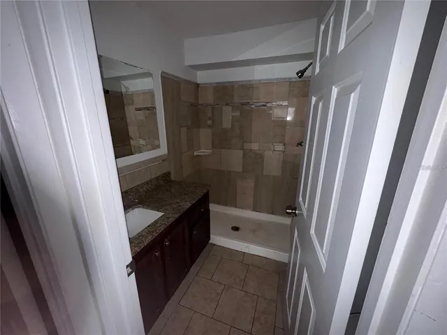 a bathroom with a sink a toilet a mirror and shower
