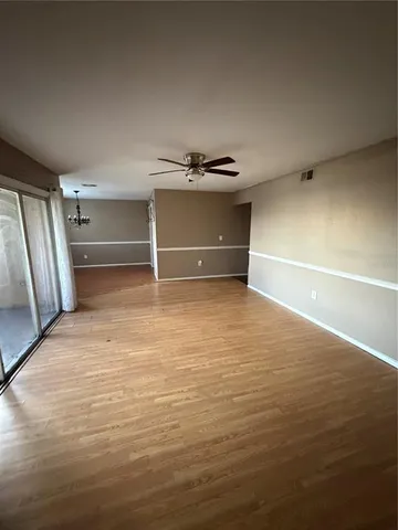 en empty room with windows and ceiling fan