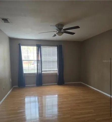 a view of a room with wooden floor and a window