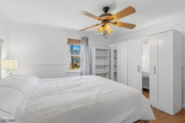 a bedroom with a bed and a ceiling fan
