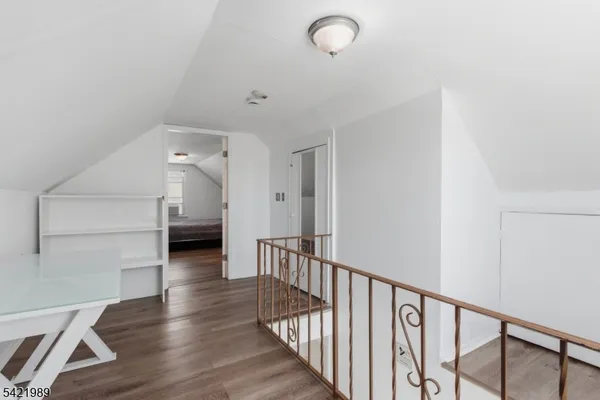 a view of a hallway with wooden floor and entryway