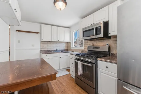 a kitchen with stainless steel appliances granite countertop a stove microwave and sink