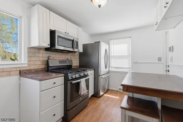 a kitchen with stainless steel appliances a stove microwave and refrigerator
