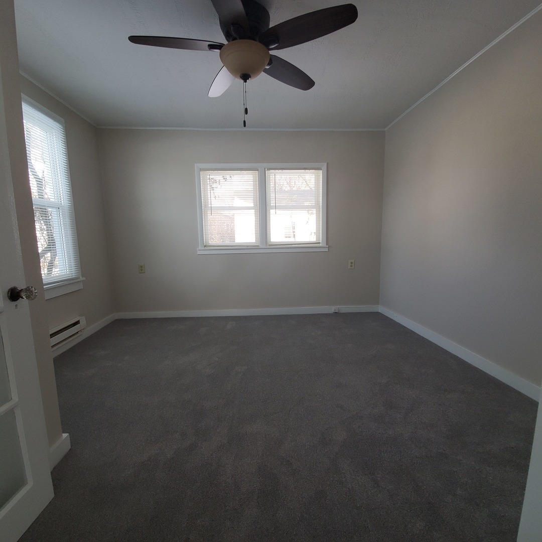 6020 Hickory Street Harvard, IL 60033 - Photo 11 of 17 en empty room with windows and chandelier fan
