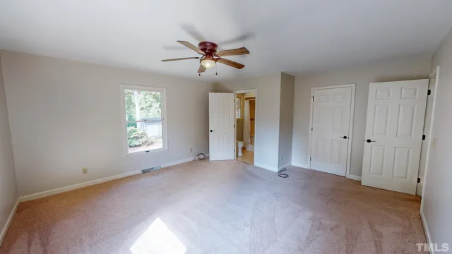 a view of a room with a ceiling fan and a window