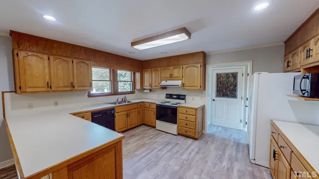 a kitchen with wooden floors and white cabinets