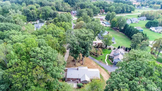 an aerial view of a house with a yard and lake view