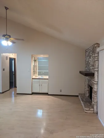 a view of an empty room with a fireplace and a window