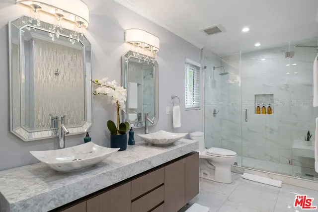 a bathroom with a granite countertop sink mirror and toilet