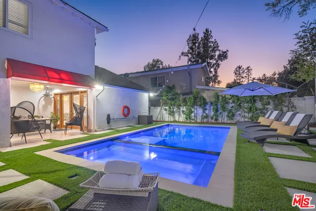 a view of a patio with table and chairs under an umbrella