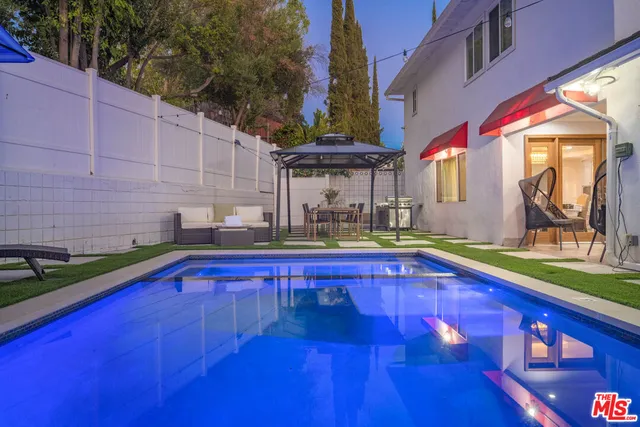 a view of a backyard with a patio and swimming pool
