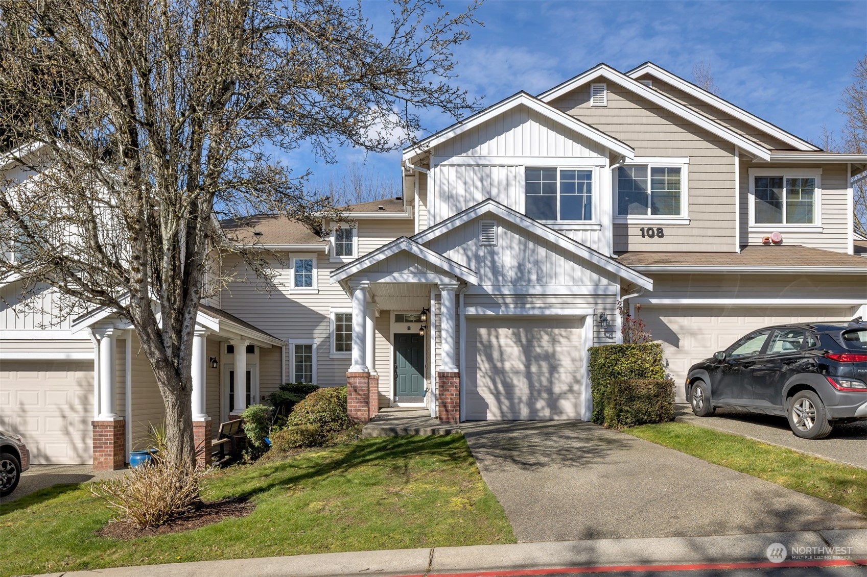 108 South 49th Street, Unit B Renton, WA 98055 - Photo 2 of 24 a view of a white house with a large windows and a yard