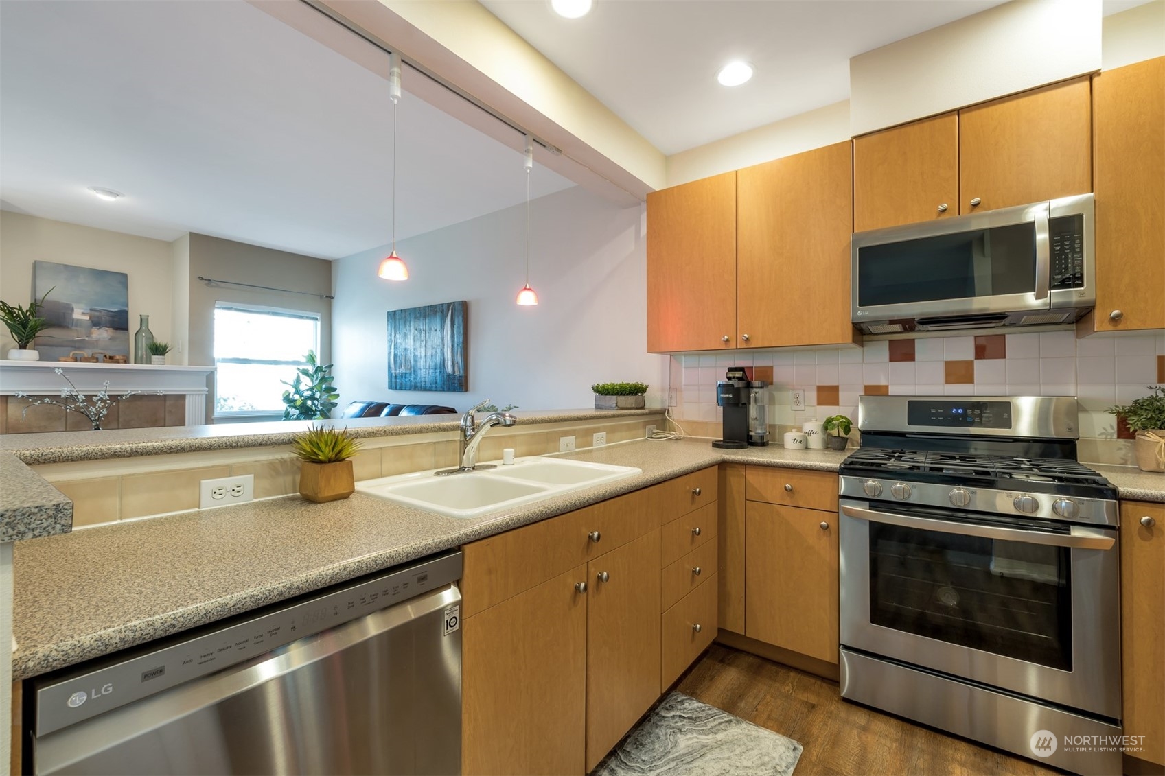 108 South 49th Street, Unit B Renton, WA 98055 - Photo 7 of 24 a kitchen with stainless steel appliances a stove sink microwave and cabinets