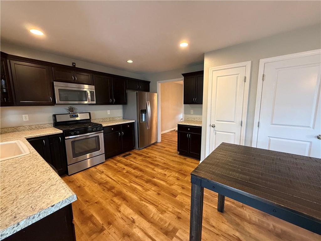 305 Garden Court Gibsonia, PA 15044 - Photo 8 of 28 a kitchen with kitchen island stainless steel appliances a stove sink microwave and cabinets