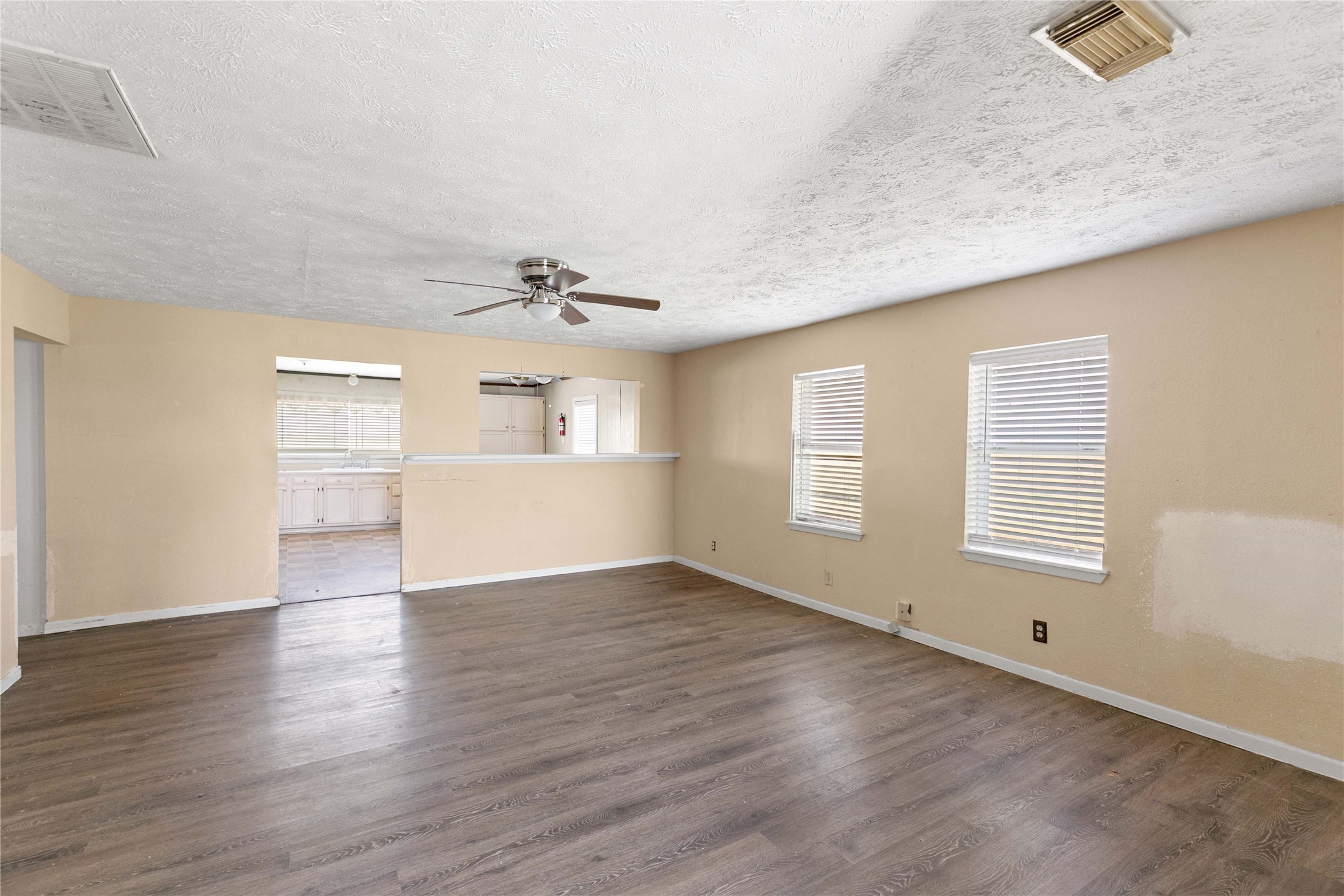910 Monument Drive Surfside Beach, TX 77541 - Photo 11 of 29 an empty room with wooden floor cabinet and windows