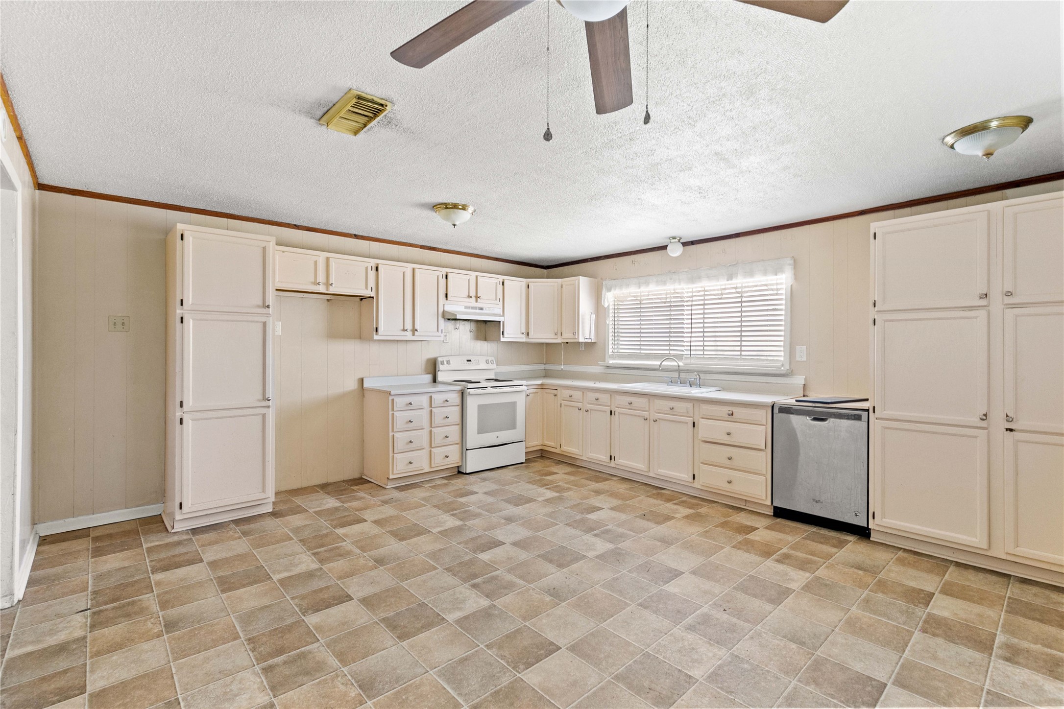 910 Monument Drive Surfside Beach, TX 77541 - Photo 14 of 29 a kitchen with white cabinets and white appliances