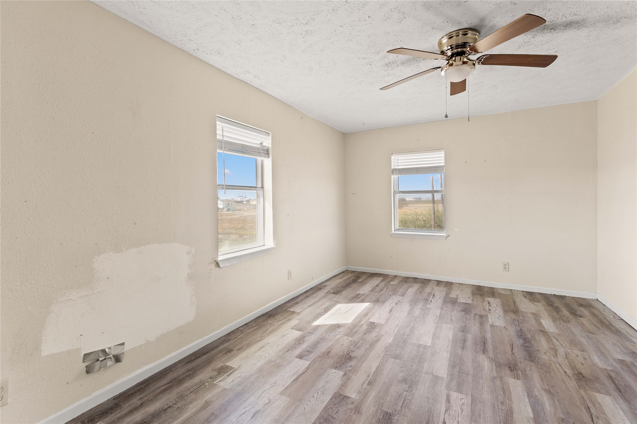 910 Monument Drive Surfside Beach, TX 77541 - Photo 20 of 29 a view of empty room with wooden floor and fan