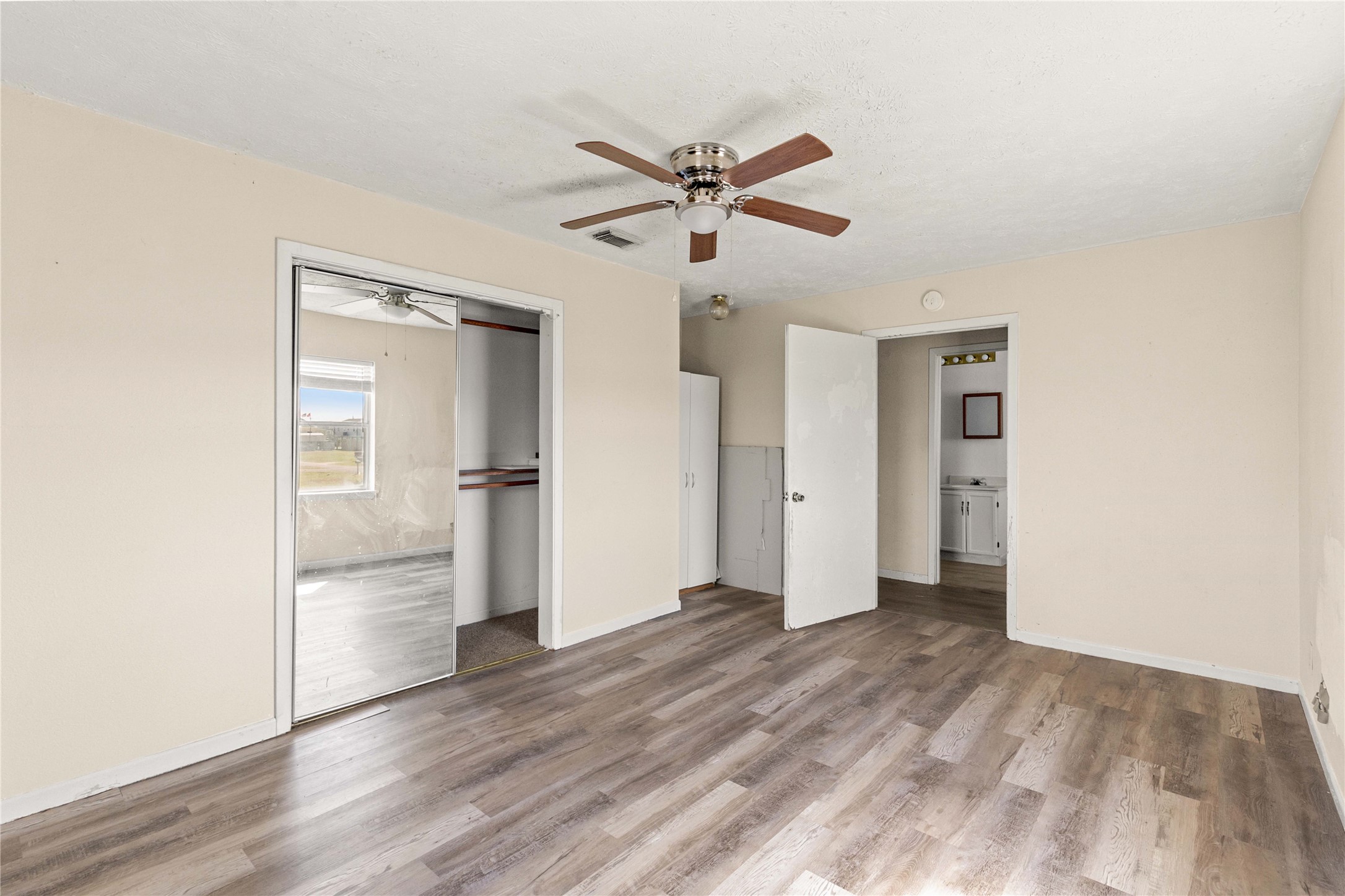 910 Monument Drive Surfside Beach, TX 77541 - Photo 21 of 29 a view of empty room with wooden floor and kitchen