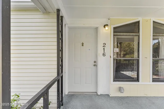 a view of an empty room with window and stairs