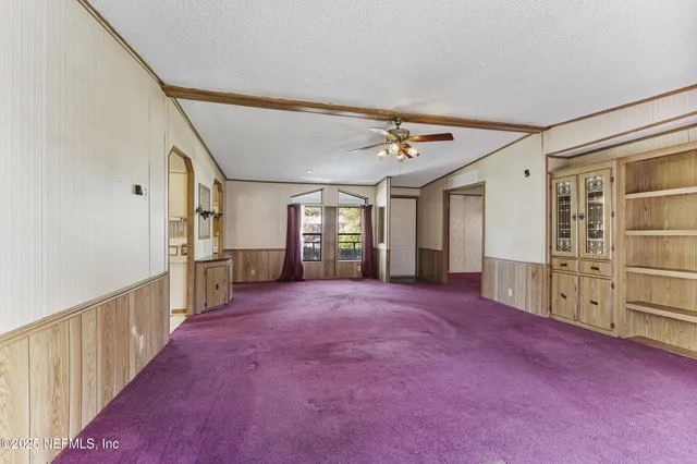 a view of a livingroom with a ceiling fan and window