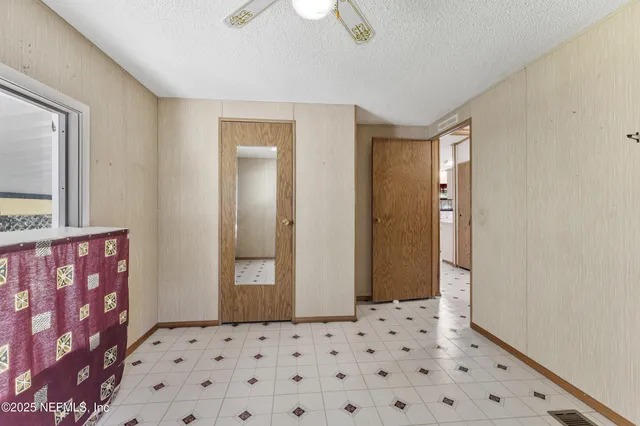 en empty room with windows and ceiling fan