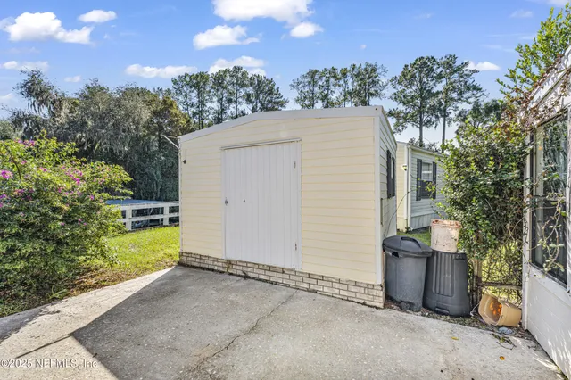 an aerial view of residential houses with outdoor space and trees