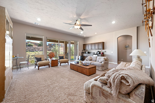 2376 Stone Crest Circle St. George, UT 84790 - Photo 31 of 61 Living area with ceiling fan, light carpet, arched walkways, recessed lighting, and a textured ceiling