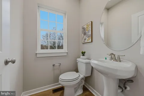 a bathroom with a toilet a sink and mirror