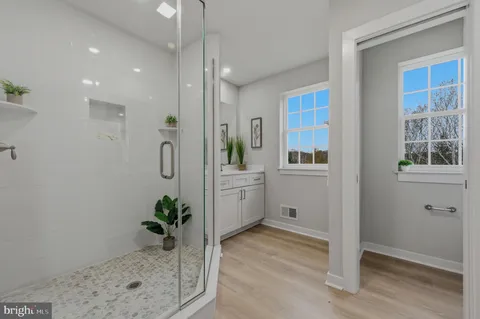 a bathroom with a tub shower and mirror