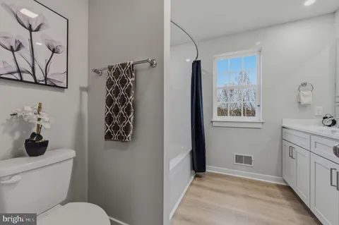 a bathroom with a toilet and a shower curtain