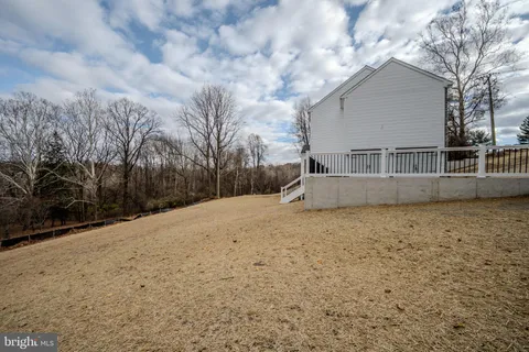 a view of large house with a big yard and large trees
