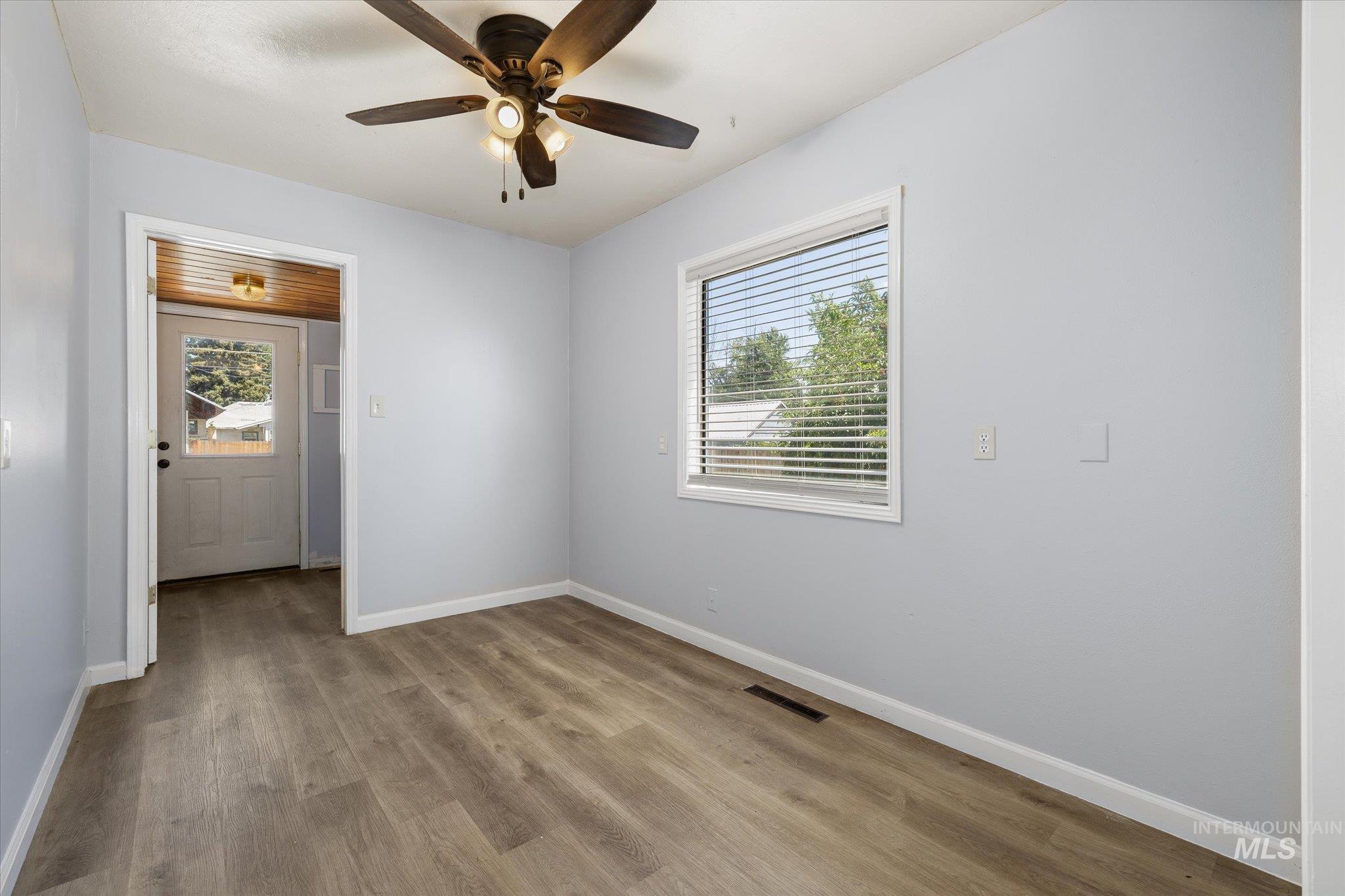 918 West 3rd Street Weiser, ID 83672 - Photo 20 of 36 Room featuring wood-finish flooring, light blue wall paint, and a ceiling fan with integrated lighting