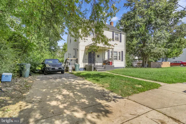 a car parked in front of a brick house next to a yard