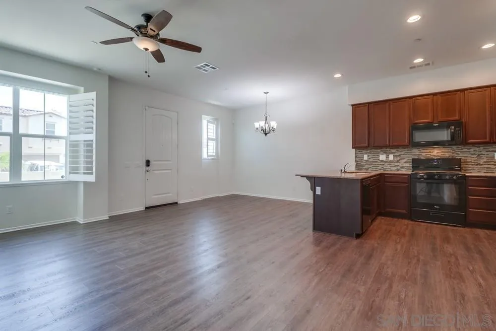 1257 Idanan Road, Unit 3 Chula Vista, CA 91913 - Photo 11 of 40 a kitchen with stainless steel appliances granite countertop a stove top oven a sink with wooden floors
