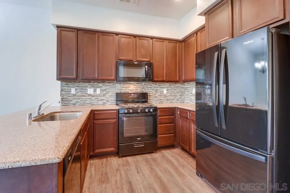 1257 Idanan Road, Unit 3 Chula Vista, CA 91913 - Photo 13 of 40 a kitchen with stainless steel appliances granite countertop a refrigerator sink and stove