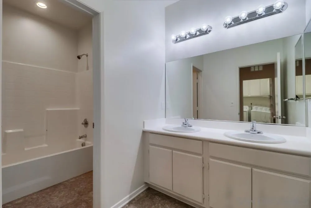 1257 Idanan Road, Unit 3 Chula Vista, CA 91913 - Photo 28 of 40 a bathroom with a double vanity sink a mirror and a bathtub