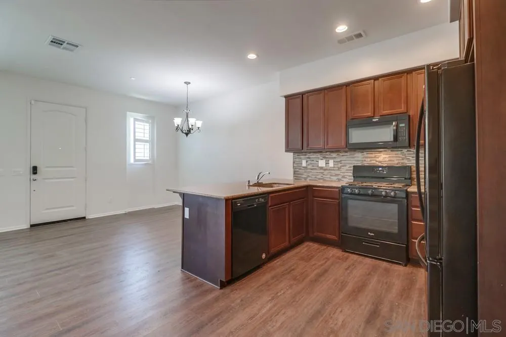 1257 Idanan Road, Unit 3 Chula Vista, CA 91913 - Photo 9 of 40 a kitchen with stainless steel appliances granite countertop a stove a sink and a refrigerator