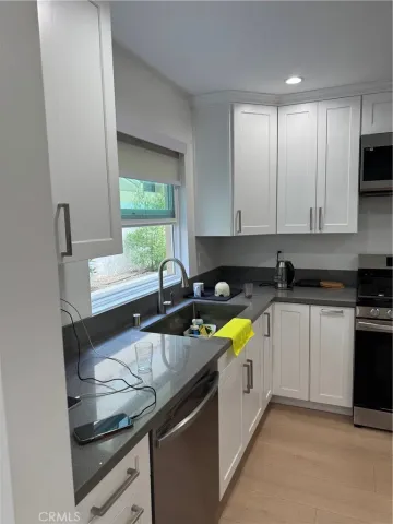 a kitchen with stainless steel appliances granite countertop a sink and a stove