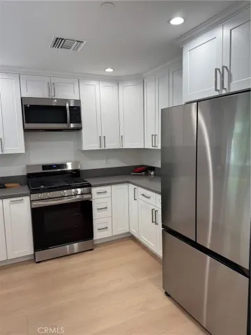 a kitchen with stainless steel appliances and white cabinets
