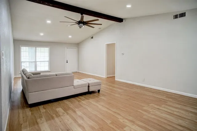 a living room with furniture and a wooden floor