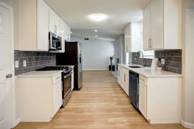 a kitchen with stainless steel appliances granite countertop a stove and a sink