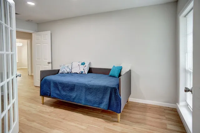 a bedroom with a bed and wooden floor