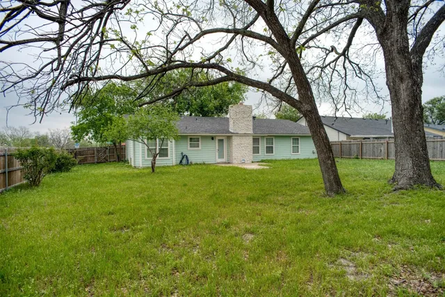 a view of a house with backyard and a tree