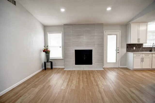 an empty room with wooden floor and fireplace
