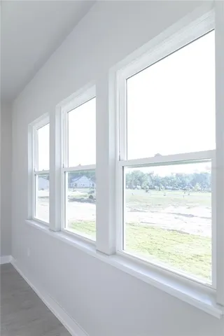 a large kitchen with granite countertop a large kitchen island white cabinetry a sink and stainless steel appliances