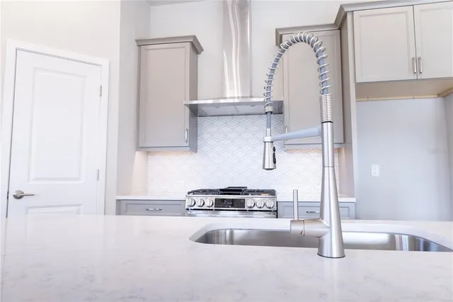 a kitchen with granite countertop a stove and a refrigerator with cabinets