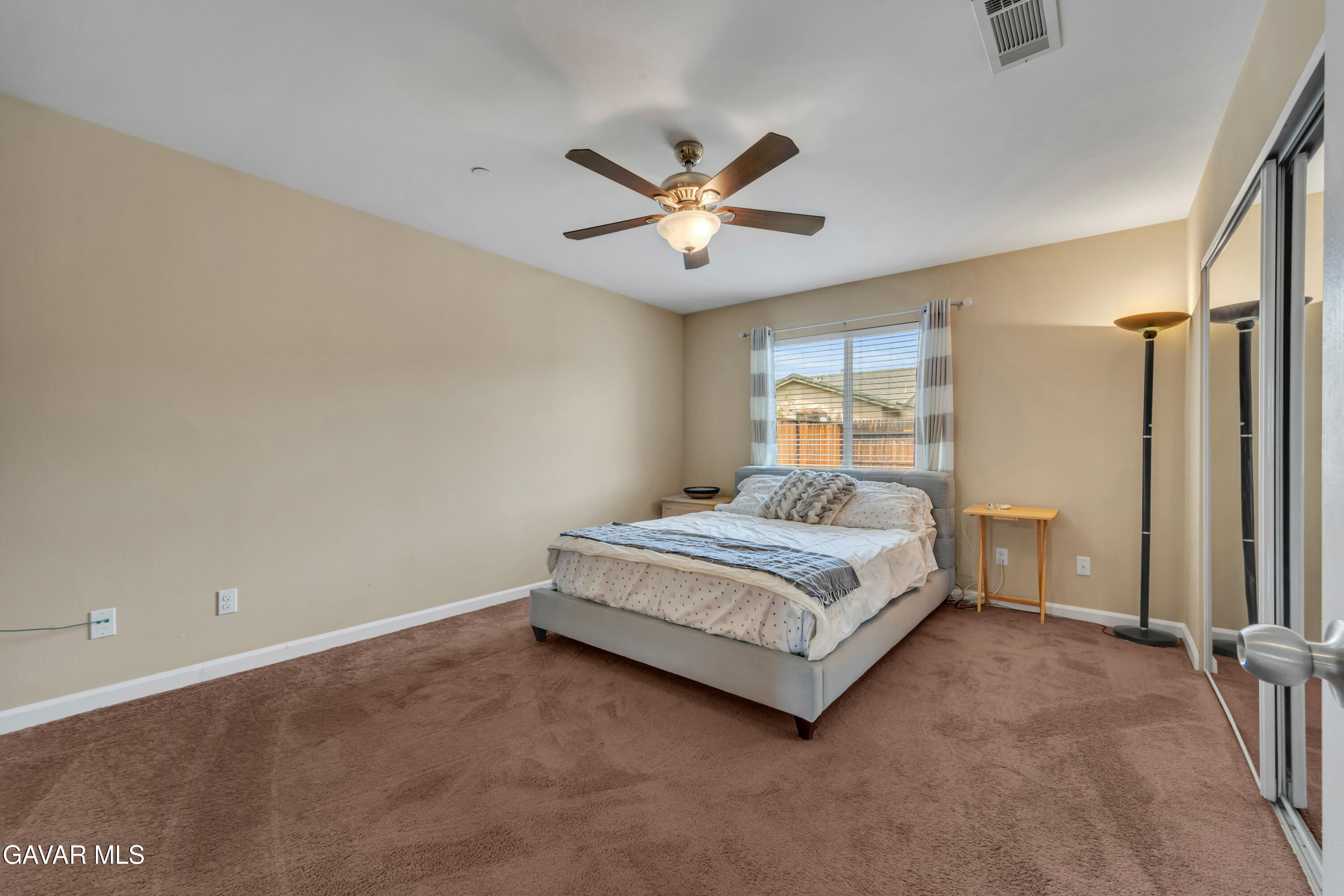 1415 Richfield Avenue Rosamond, CA 93560 - Photo 17 of 21 a spacious bedroom with a bed and a ceiling fan