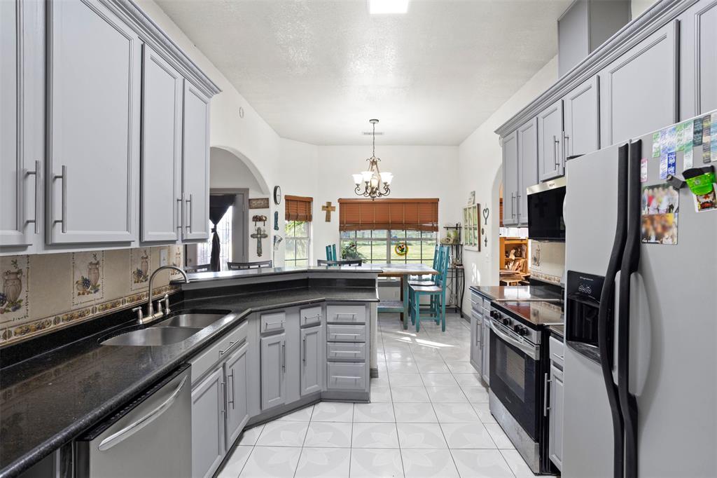 6524 Fair Road Kaufman, TX 75142 - Photo 13 of 30 a kitchen with stainless steel appliances granite countertop a refrigerator a stove and a sink